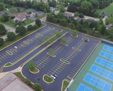 Aerial view of large parking lot with completed blacktop sealcoat and yellow parking spaces
